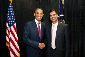 President Obama and Dr Srdihar Kota in suits shaking hands while smiling at camera